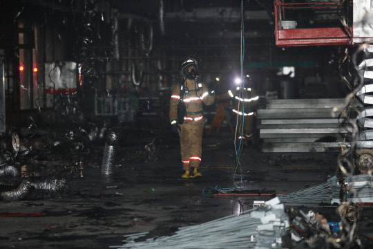 29일 오후 서울 강서구 김포공항 국제선 터미널 1층 공사현장에서 소방관들이 화재를 진압하고 나오고 있다.
